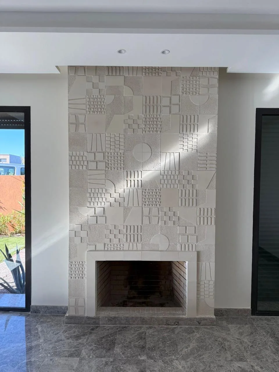 Détail du revêtement clair autour de la cheminée de la villa à Marrakech