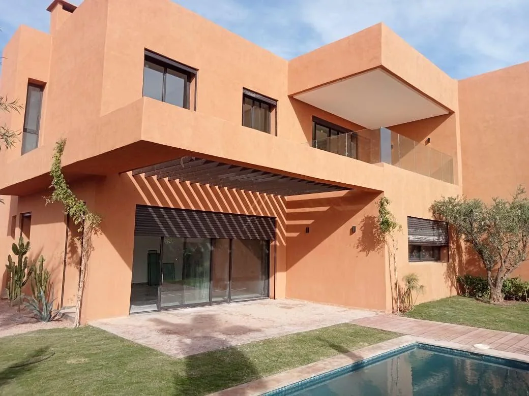 Façade ocre, terrasse et piscine de la villa à Marrakech